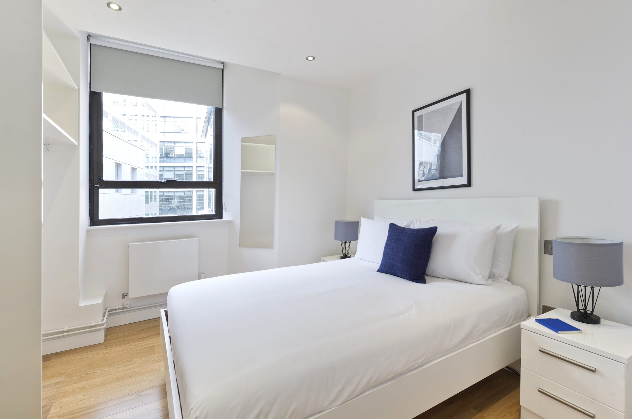 Light bedroom, white double bed, furnishings and walls. Window next to the bed